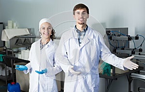 Two workers in lab coats at dairy production