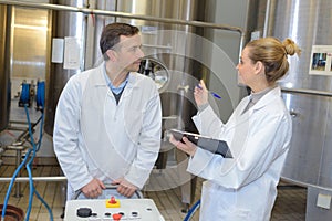 Two workers in labcoat working at factory photo