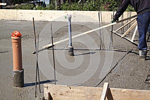 two workers leveling fresh concrete slab with a special working