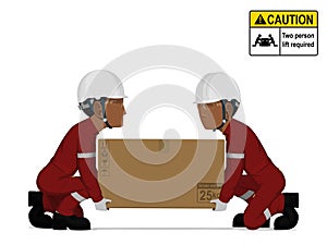 Two workers is lifting a big box on the floor