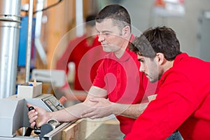 two workers operating on machine