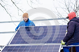 Two workers in process of installation of solar battery. Winter