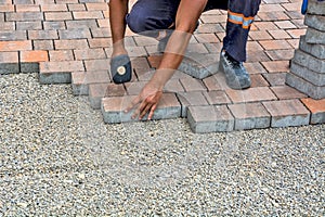 two workers putting the bricks on the ground in front of a brick building