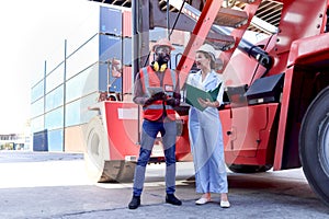 Two workers with safety helmet at logistic shipping cargo containers yard. African engineer man using digital tablet to report