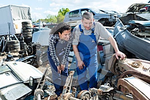 Two workers in scrap metal yard