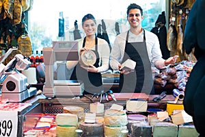 Two workers selling cheese and sausages