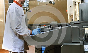 Two workers start making blocks of cheese in a factory