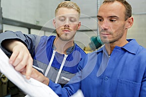 two workers talking about paper