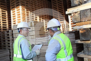 Two workers talking beside on stacking pallet