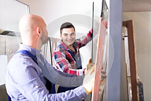 Two workers working with glass