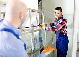 Two workers working with glass