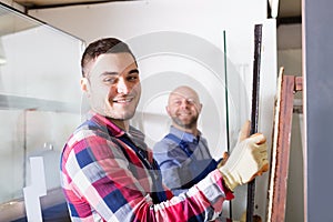 Two workers working with glass