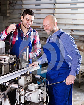 Two workers working on machine