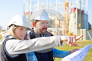 Two workers working outside on a construction site