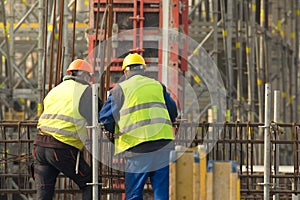 Two labours in yellow at the construction site