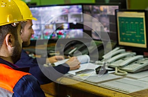 The two workers in yellow helmets in control panel in the laboratory