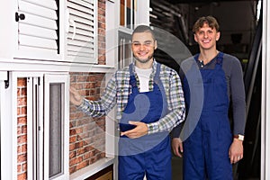 Two workmen inspecting windows