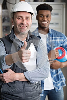 Two workmen making thumbs-up gesture