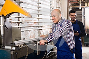 Two workmen near cutter-lathe machine