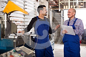 Two workmen near cutter-lathe machine