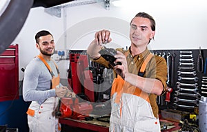 Two workmen toiling in workshop