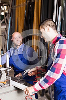 Two workmen working on machine