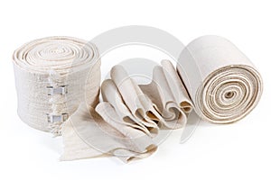 Two woven elastic medical bandages in roll and partially unwound