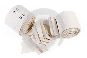 Two woven elastic medical bandages in roll and partially unwound