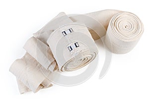 Two woven elastic medical bandages, rolled and partially unwound