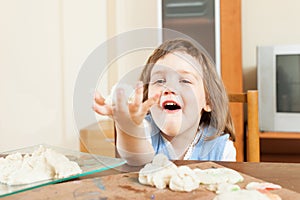 Two year girl sculpting from plasticine or dough in home