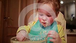 Two year old boy is having dinner independently.