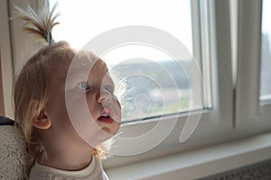 Two year old child in the corner of the frame with an emotion of surprise on his face. Place for text