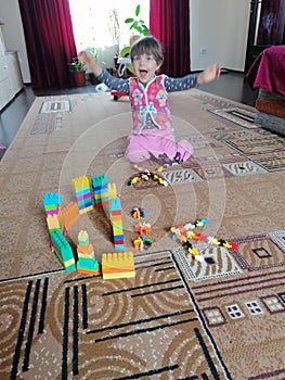 Two-year-old girl playing with lego toys in living room