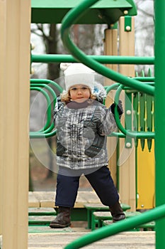 Two year old girl surmounting obstacle course on the playground photo