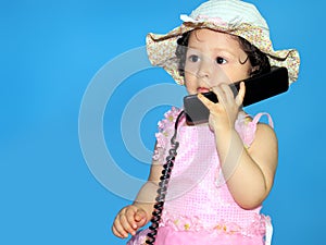 Two year old girl talking on the telephone