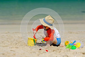 Two year old toddler playing on beach