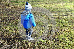 Two years old boy walking around yard