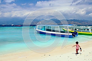 Two years old cute little kid enjoying his time in the sand somewhere between Surf Point beach and  Harbor beach in Gili Trawangan