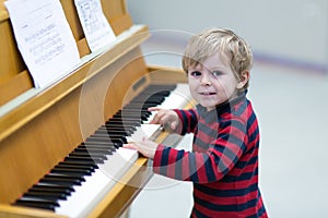 Two years old toddler boy playing piano