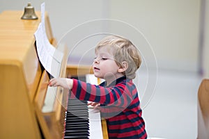 Two years old toddler boy playing piano