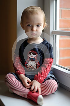 Two years old toddler girl by the window