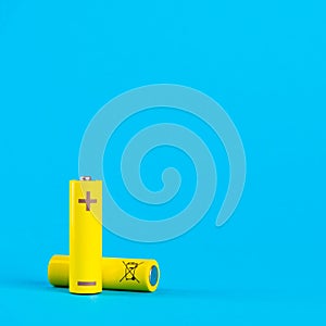 Two yellow AA alkaline batteries or NiMH rechargeable batteries on a blue background with space for text. Power elements