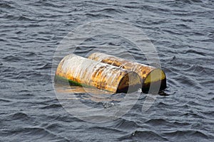 Two yellow barrels drift on water