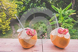 Two Yellow Coconut with straws with Red Orchids