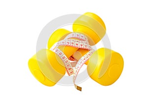 Two yellow dumbbells and tape measure isolated on the white back