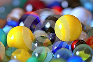 Two yellow marbles in a big collection of coloured marbles - stock photo