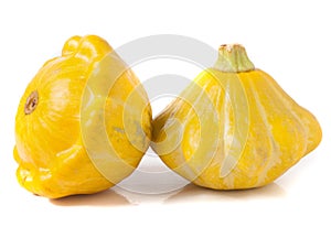 Two yellow pattypan squash isolated on white background