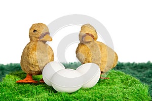 Two yellow toy chicks with three eggs