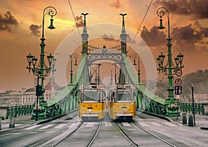 Two yellow trams on the Liberty Bridge in Budapest.