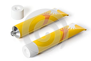Two yellow tubes of ointment on a white background. Full depth of field
